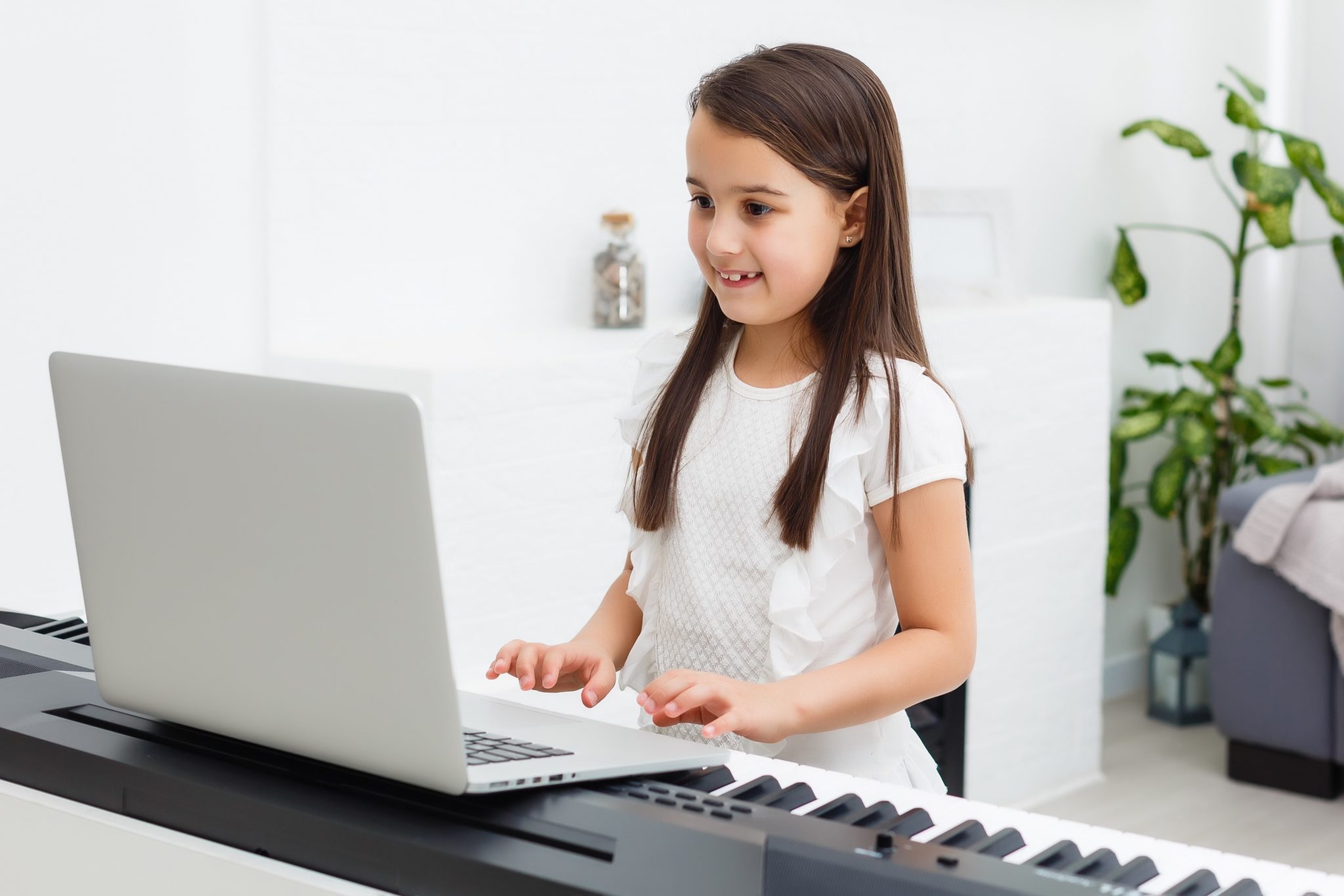 Girl playing keyboard with laptop
